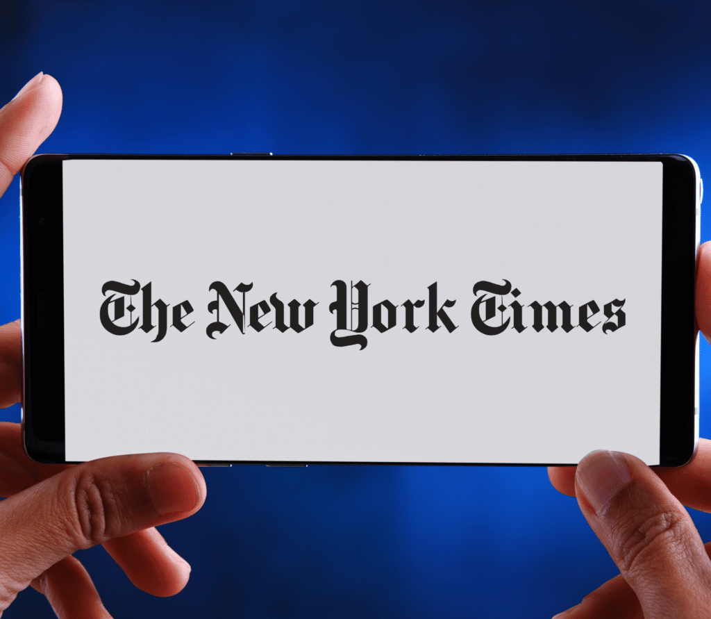 The New York Times app displayed on a smartphone, held horizontally in a reader's hands