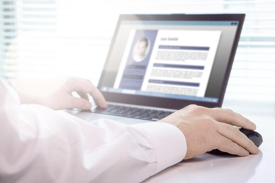 Job seeker and applicant writing his resume and CV with laptop. Modern and visual electronic curriculum vitae in social media. Work experience document in computer screen. Job search and unemployment.