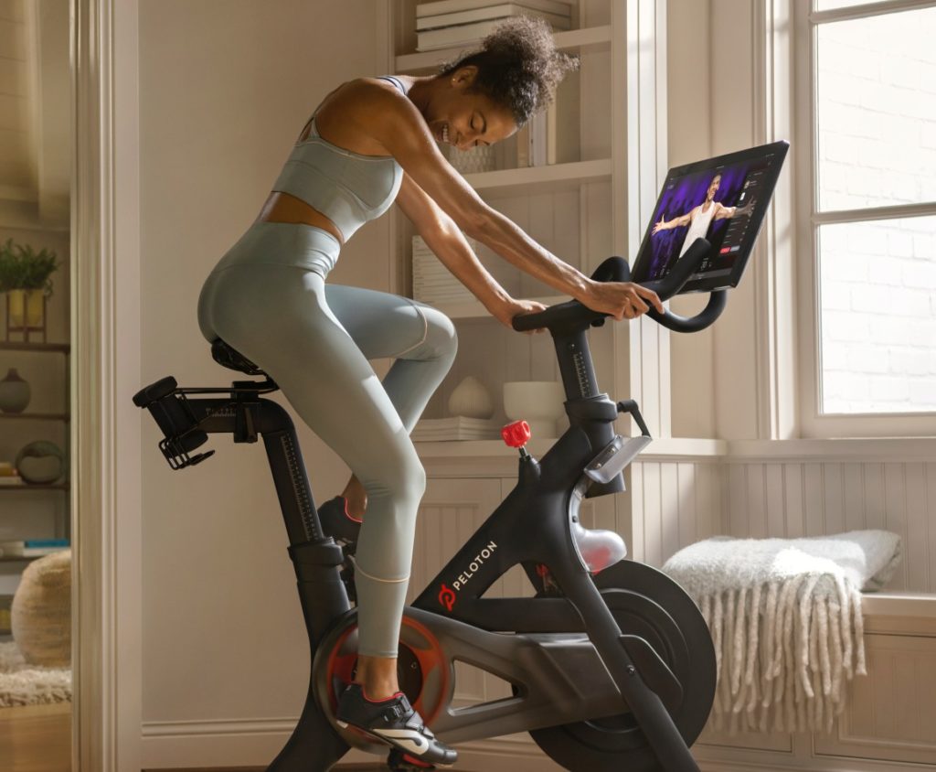 Woman riding Peloton bike at home