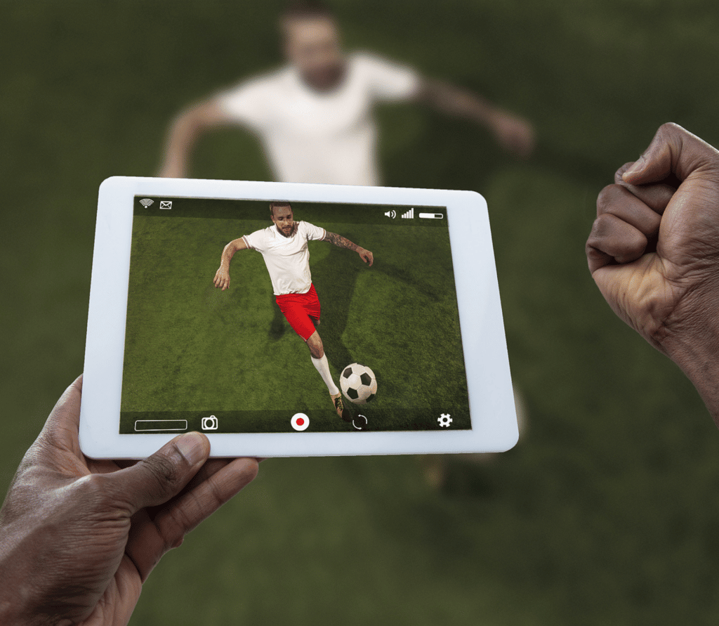 Man watching sports on tablet cheers for his team