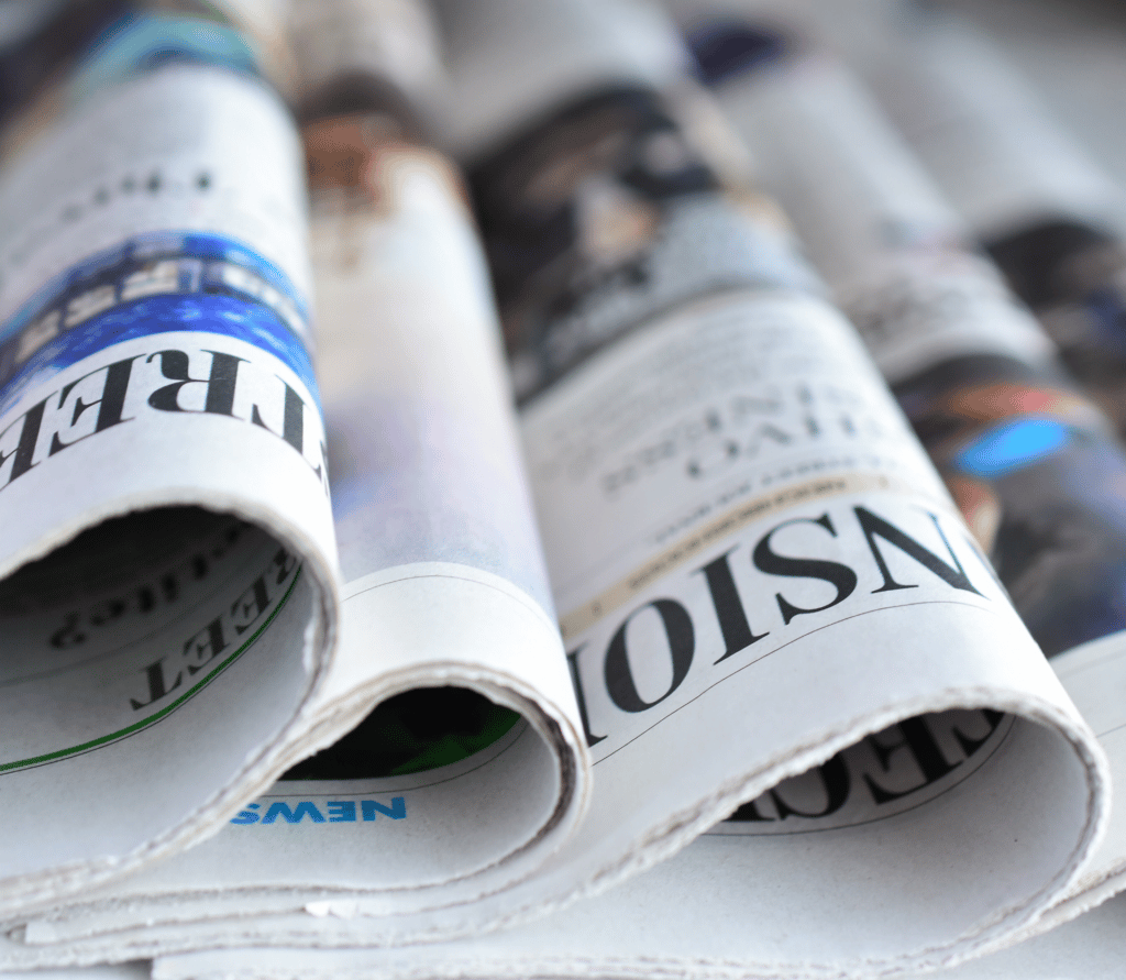 Newspapers on counter showing subscription business headlines