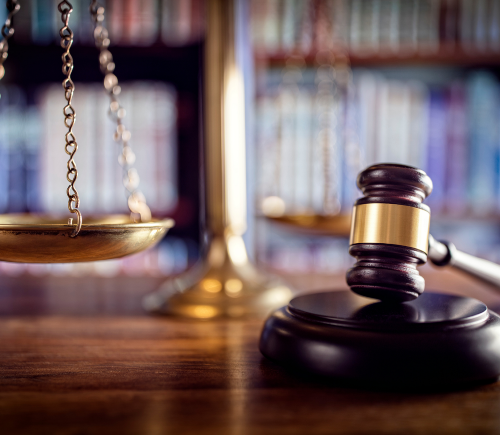 Gavel and scales of justice in law library, signifying law, justice and compliance