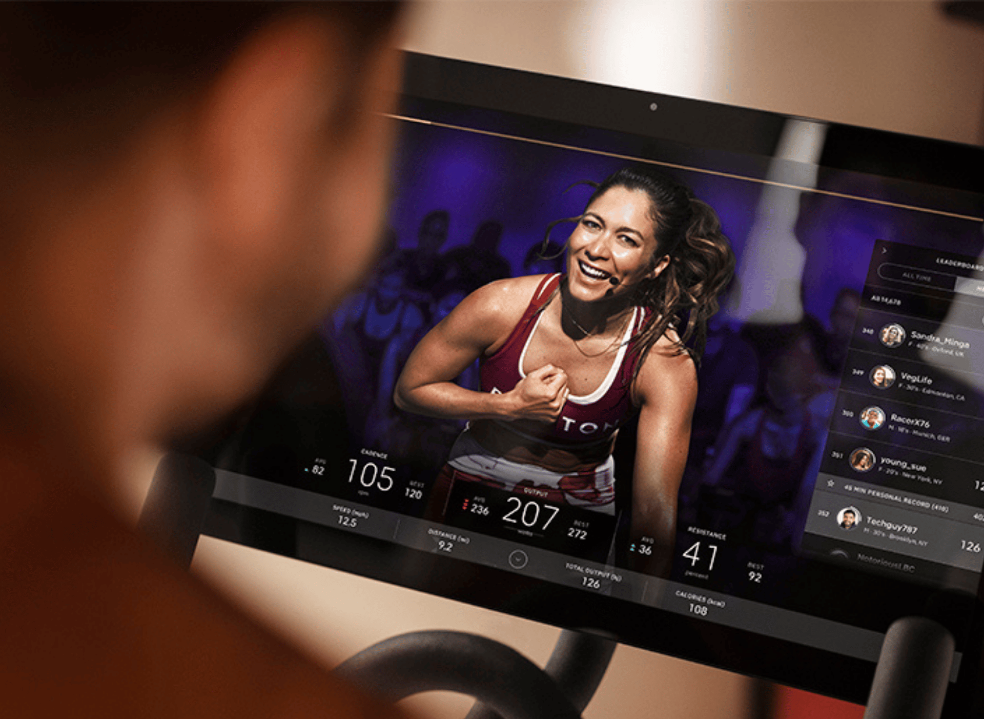 Man sits on Peloton bike watching a live class