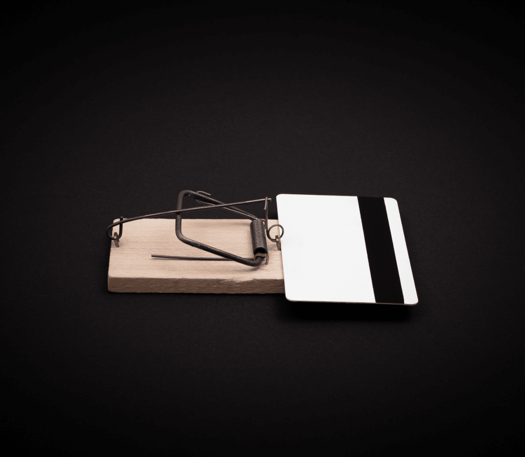 Credit card in a mouse trap, signifying subscription tricks and traps