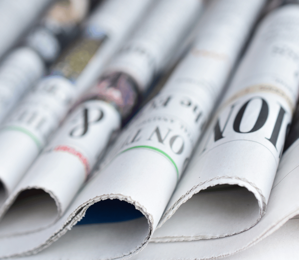 Sections of a newspaper fanned across a desk