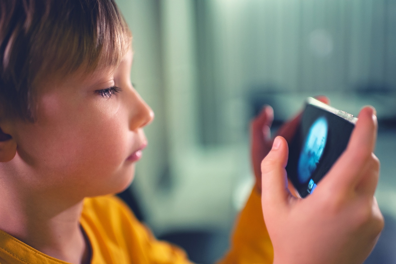 Child plays game on mobile device.