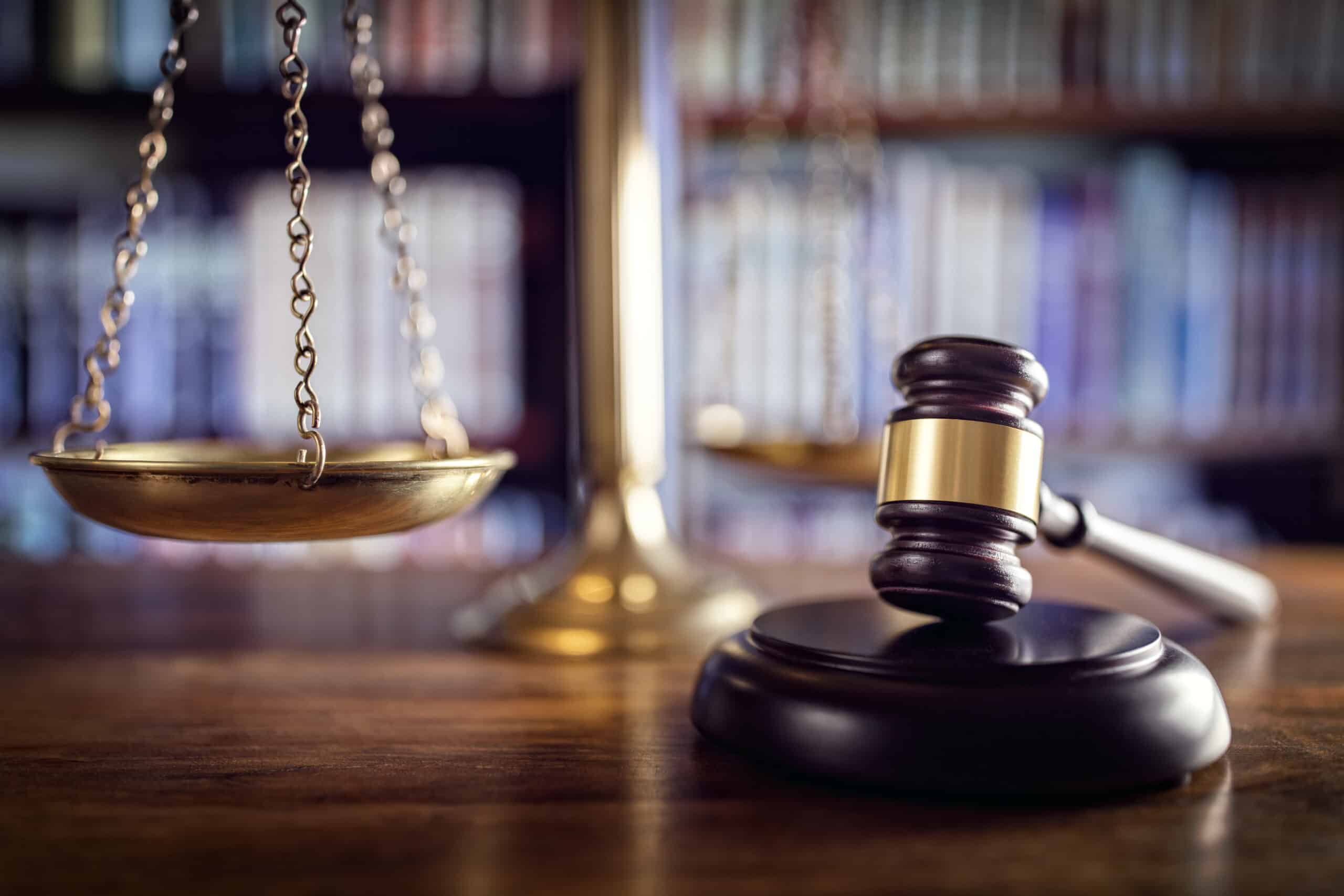 Gavel and scales of justice in law library, signifying law, justice and compliance