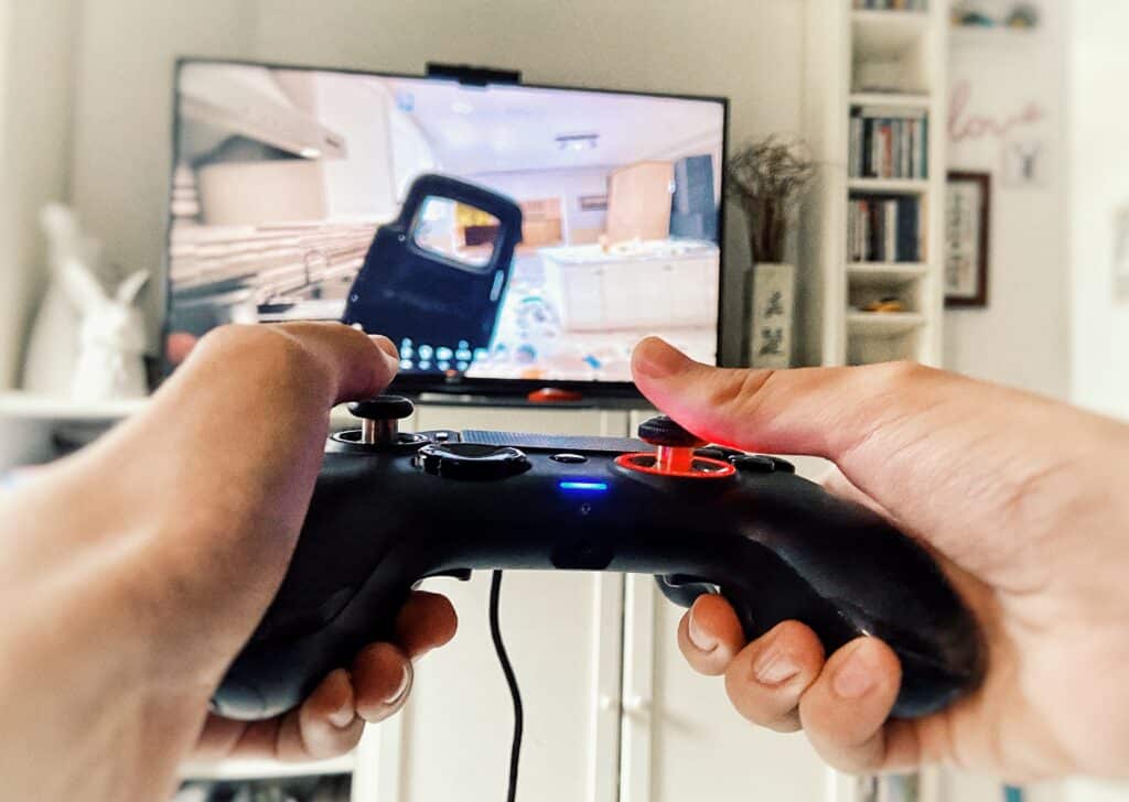 Sony PlayStation controller pointed at a big screen TV