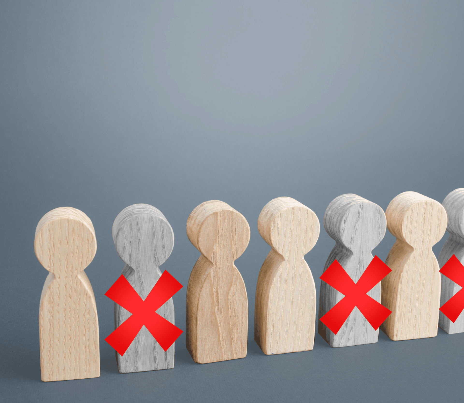 Six wooden people, three with red Xs on them, representing staffing cuts