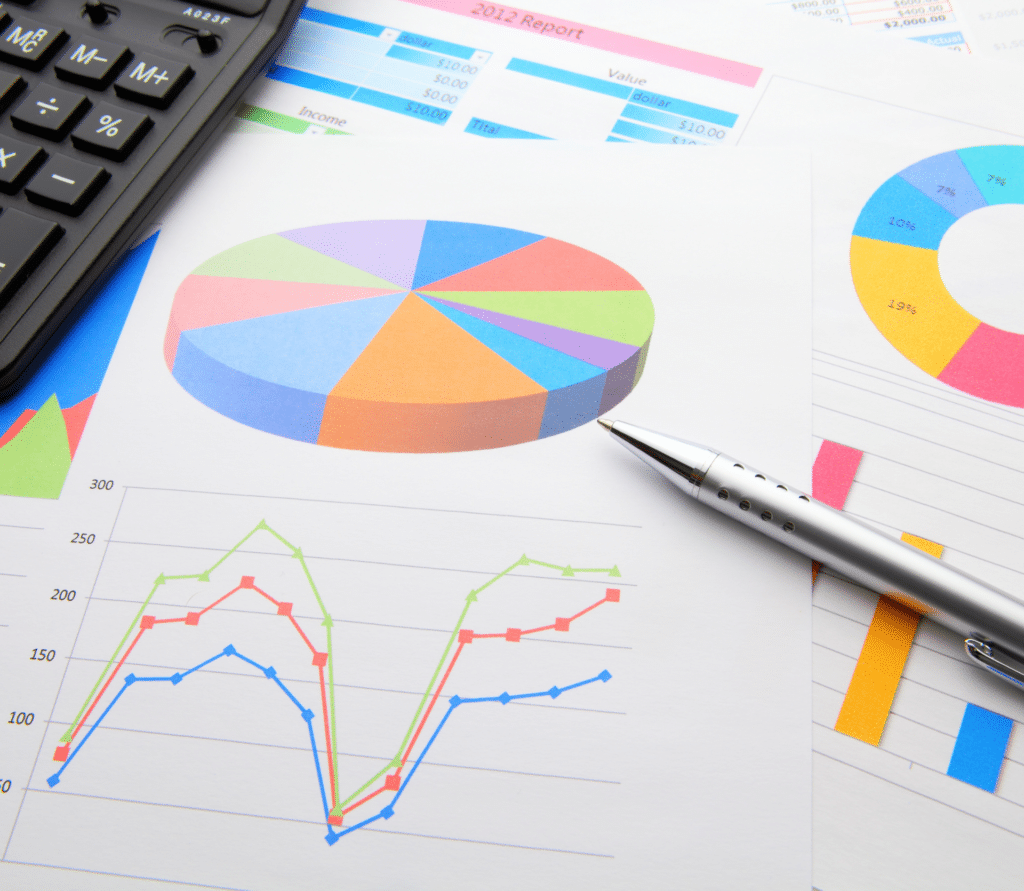 Colorful charts and graphs next to silver pen and calculator, representing review of usage data