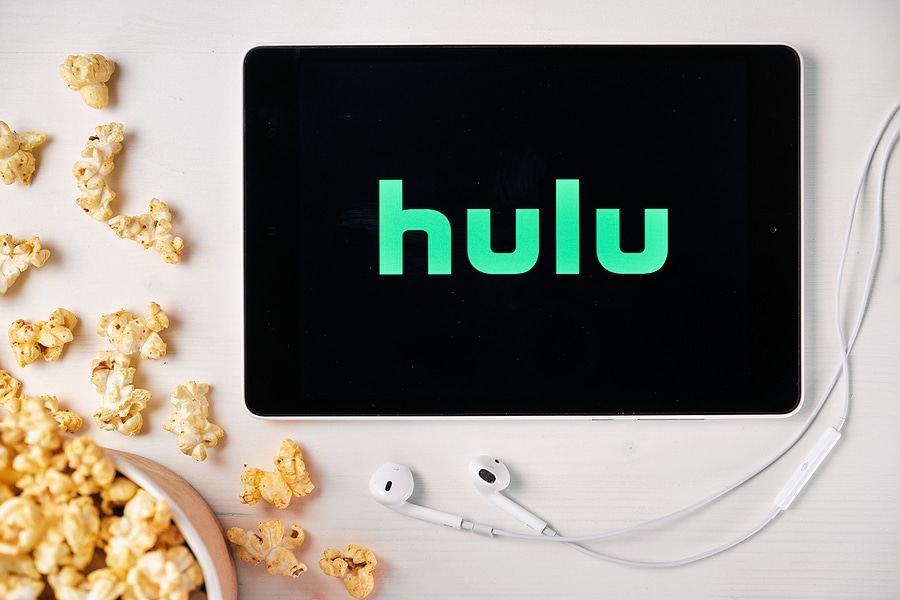 Hulu logo displayed on tablet next to spilled popcorn and headphones