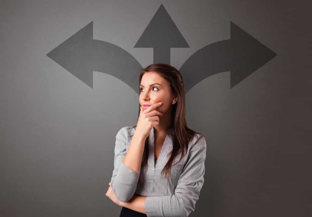 Woman standing in front of three arrows, one pointing left, one straight up and one to the right, signifying a tough choice - Stranger Things or Star Wars