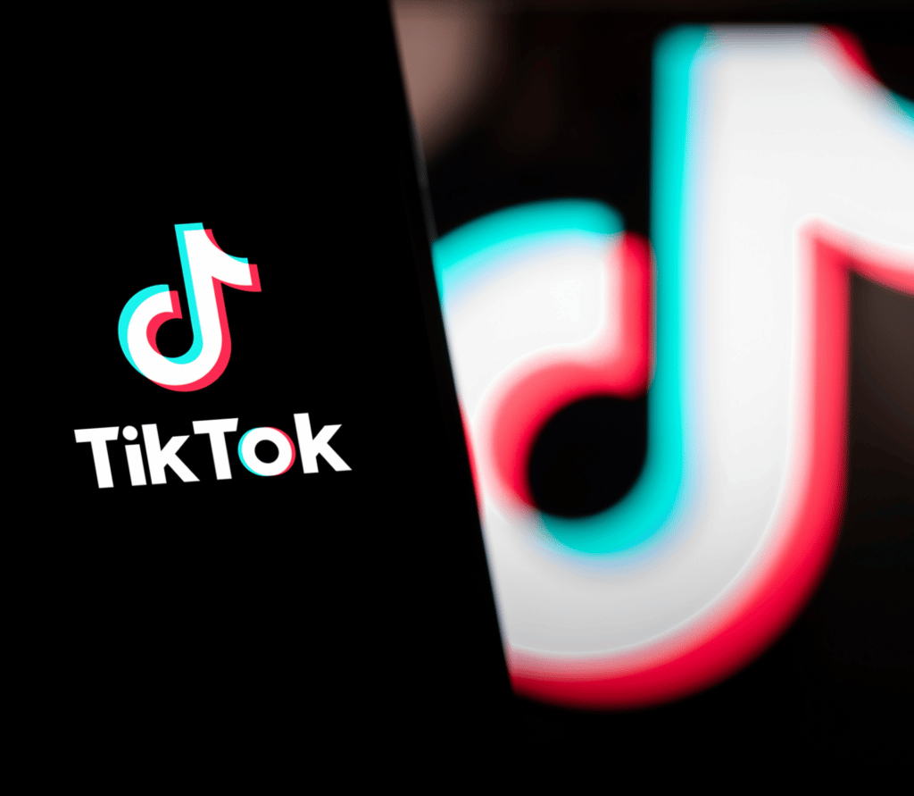 TikTok logo displayed on a smartphone with TikTok logo displayed in the background.