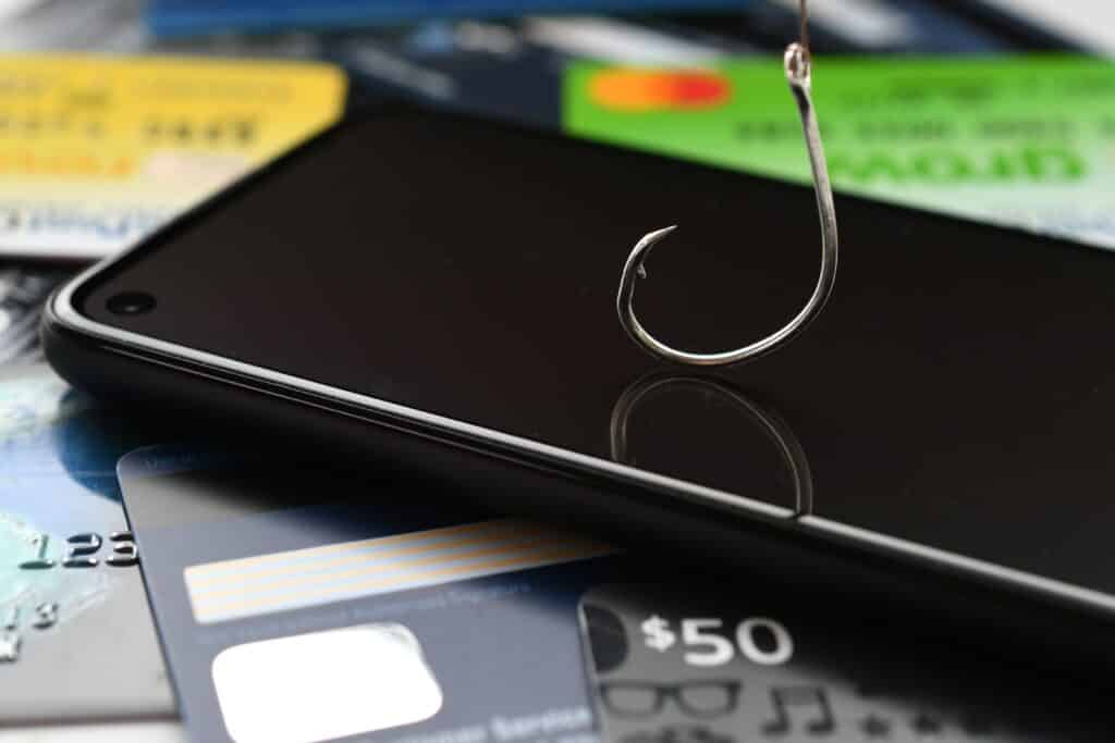 Mobile phone with fish hook, on top of credit cards