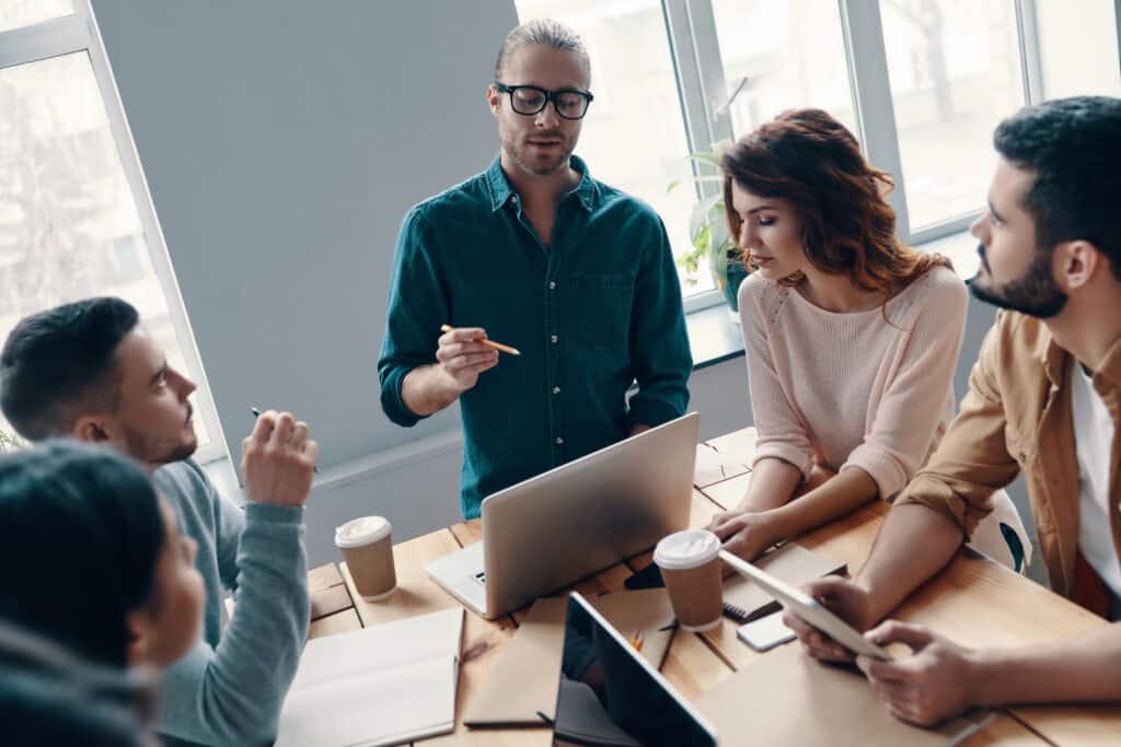 A group of managers around a table discussing a possible technology solution