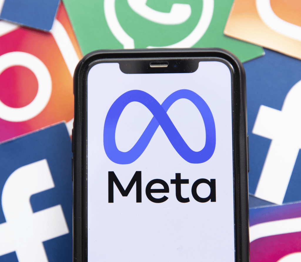 Meta logo on smartphone with Facebook, Instagram and WhatsApp logos in the background