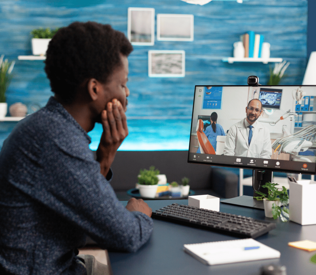 African American does telehealth visit with his healthcare provider via his desktop computer