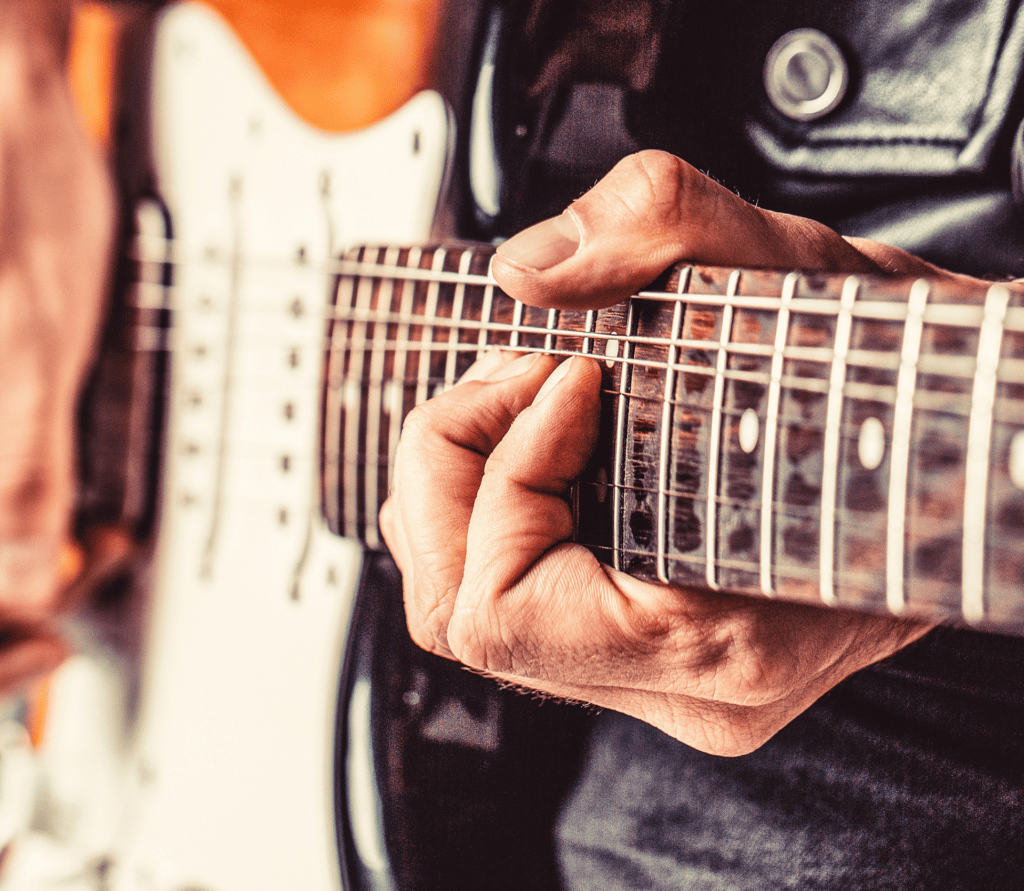 Close-up of man playing the electric guitar