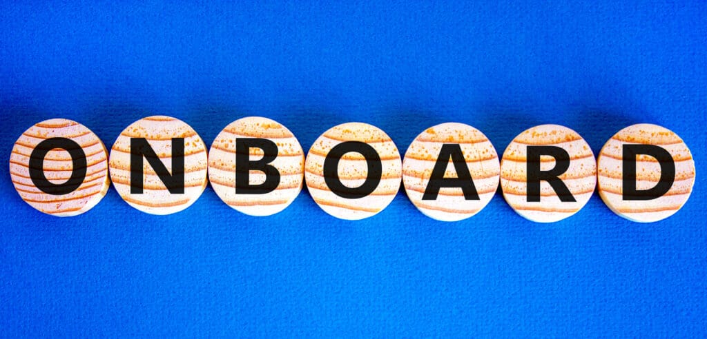 The word Onboard typed out on wooden letters, each with a different letter, on a blue background.