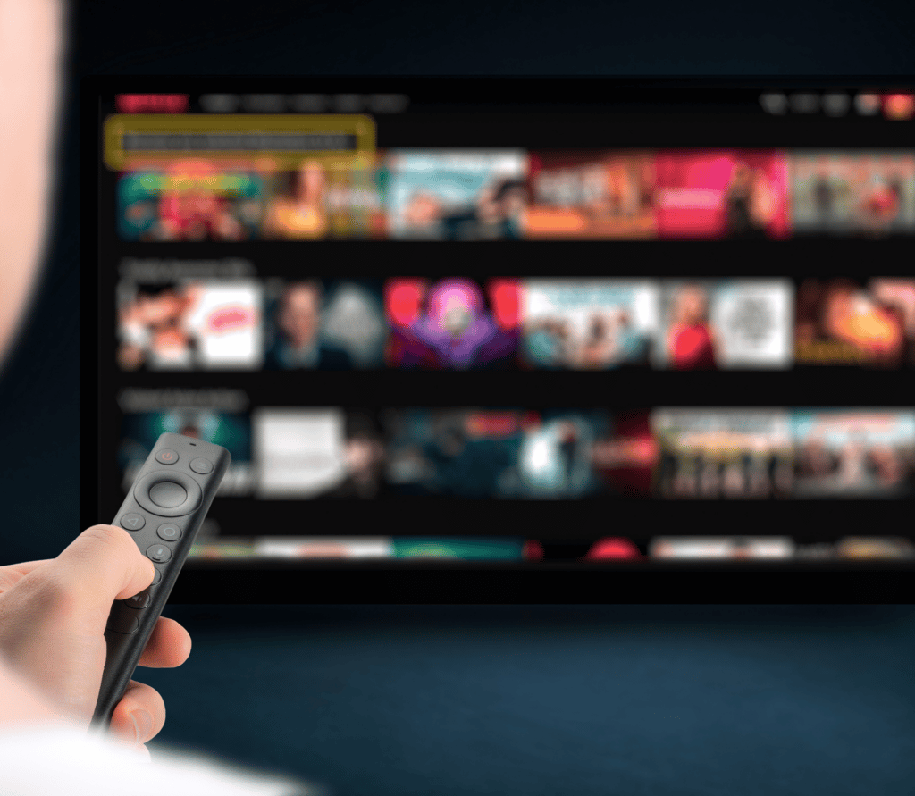 Viewer points remote at dashboard showing streaming video on demand program options