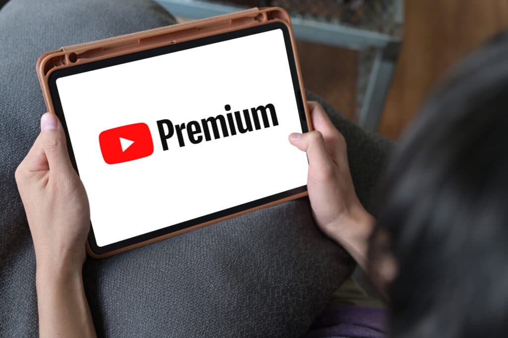 Man Watching YouTube Premium On iPad , With YouTube Premium, enjoy ad-free access, downloads, and background play on YouTube and YouTube Music by google