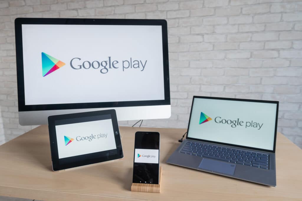 Google play logo on the screens of a phone, digital tablet, laptop and computer. A store of applications, books, music, games and movies for all digital devices on the android.