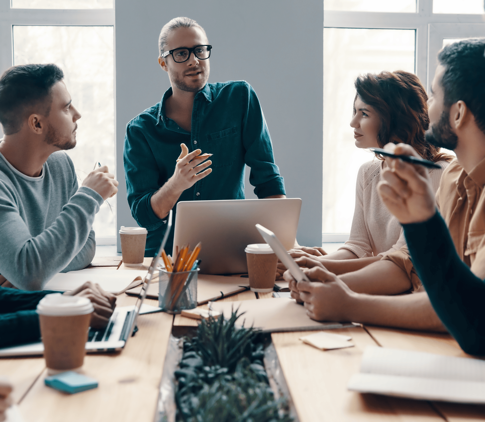 Planning new business strategy. Group of young modern people in smart casual wear discussing something while working in the creative office