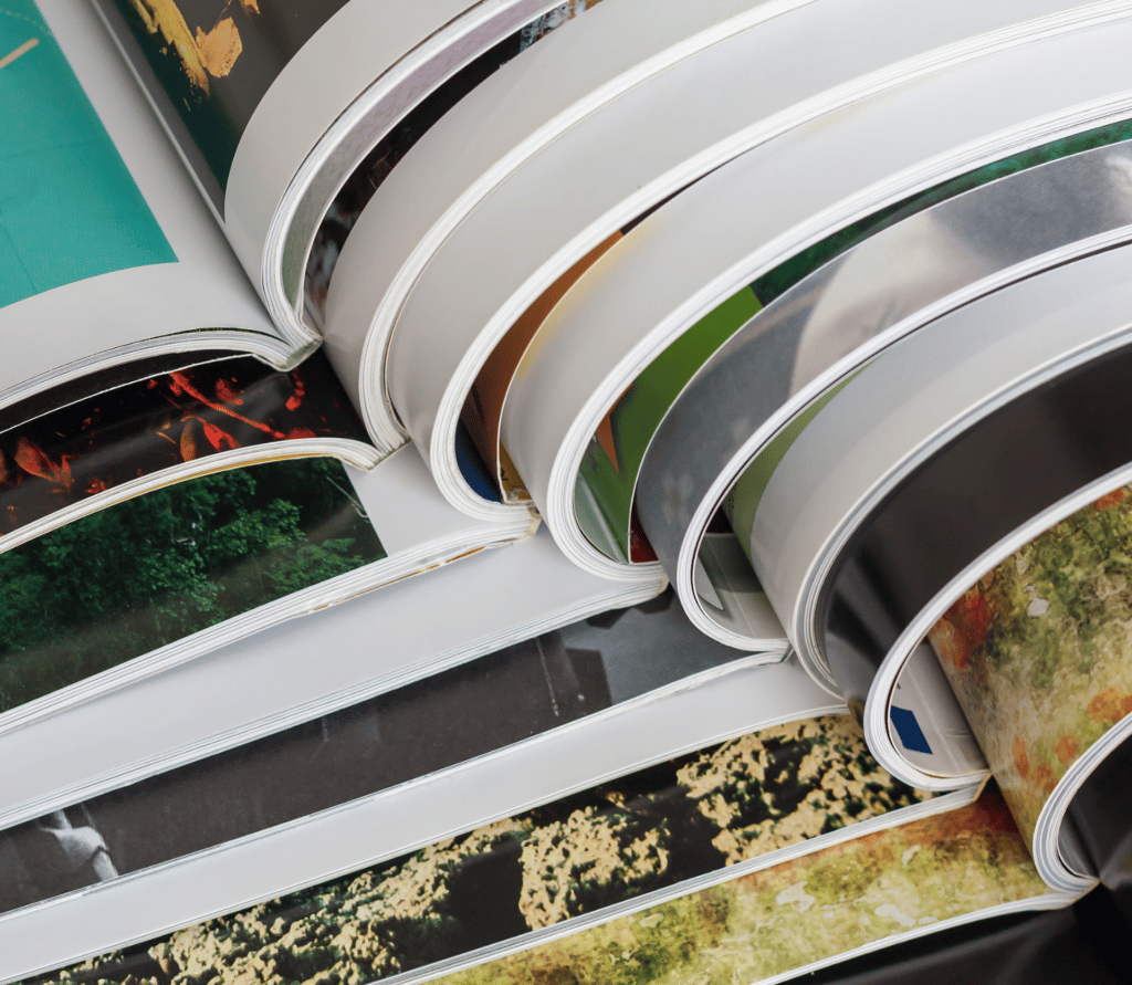 open glossy magazines stacked and fanned on table