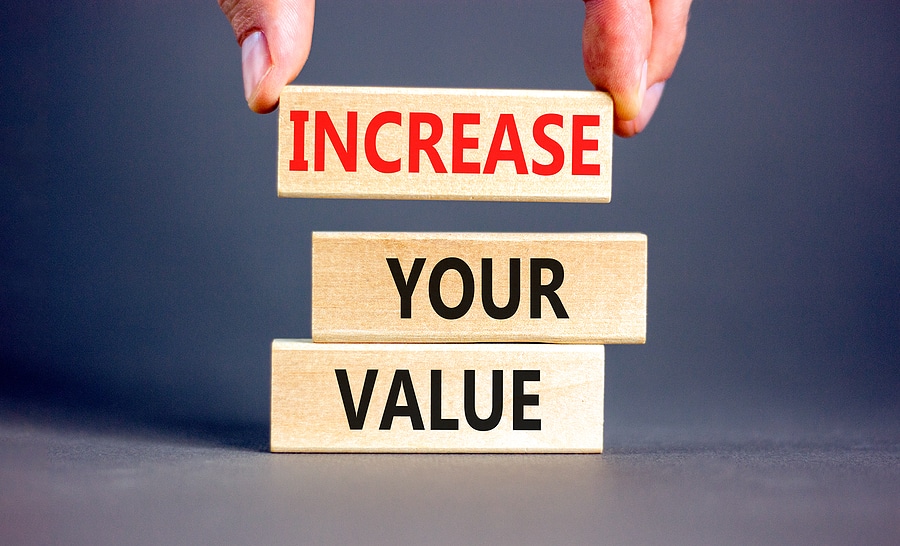 Increase your value symbol. Concept words Increase your value on wooden blocks on a beautiful grey table grey background. Businessman hand. Business increase your value concept