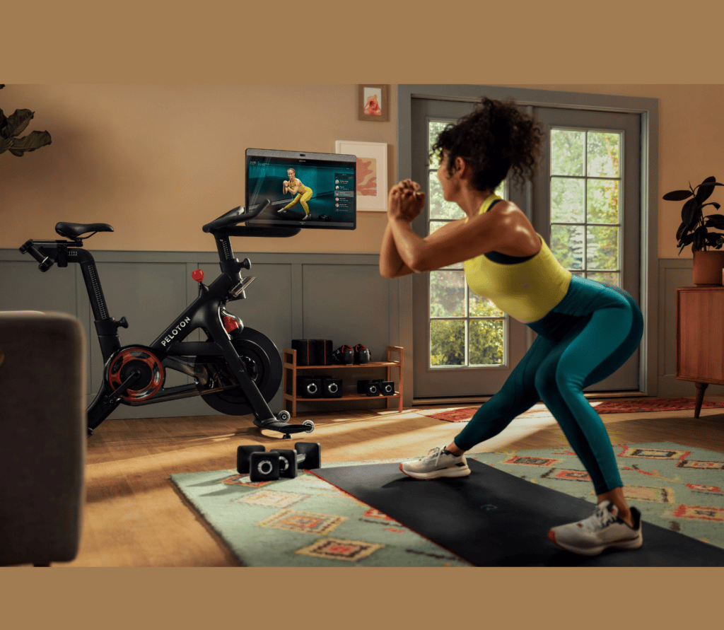 Woman exercising in her living room with Peloton app and the Bike+.