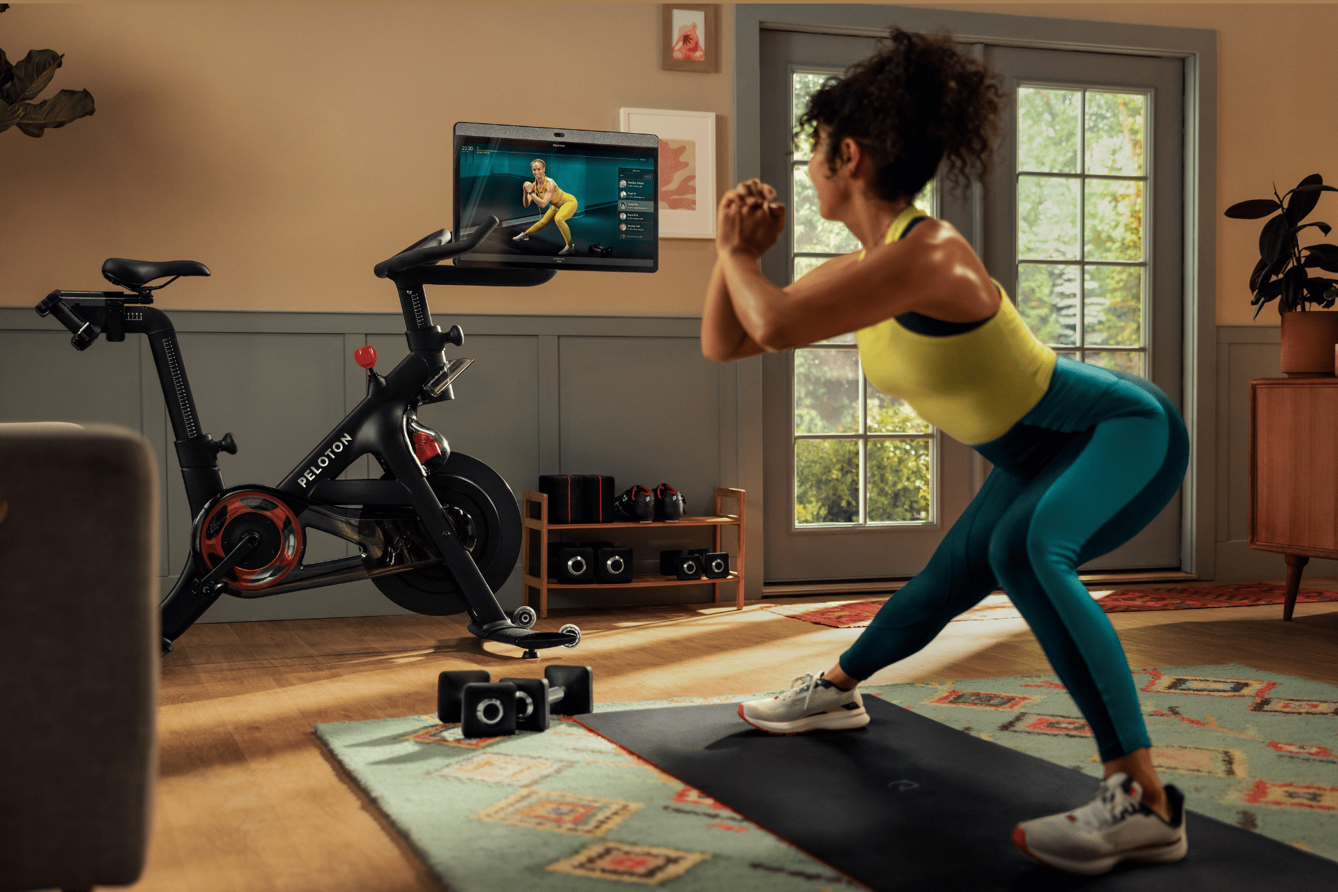 Woman exercising in her living room with Peloton app and the Bike+.