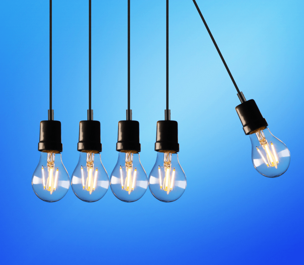 Five light bulbs hanging on strings on blue background