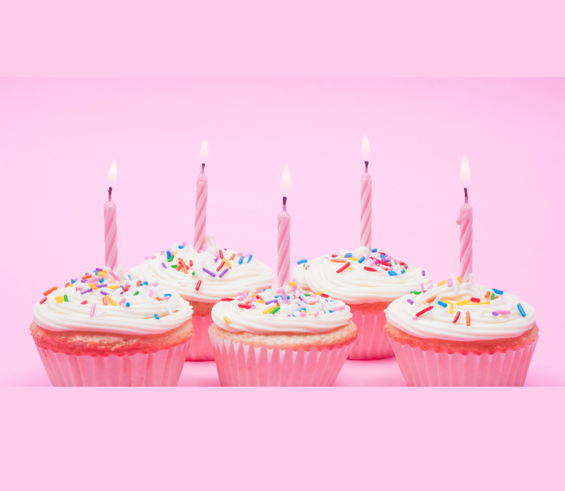 5 cupcakes with candles on pink background