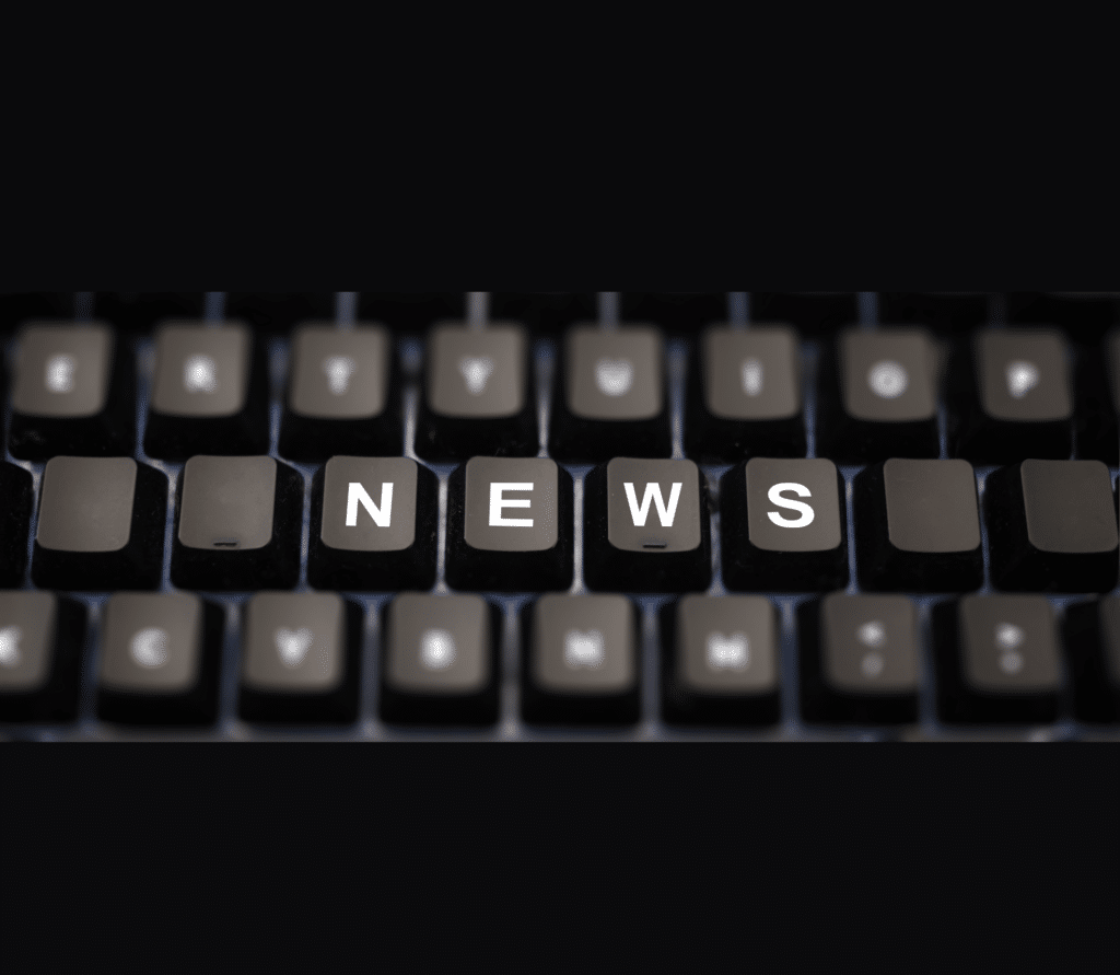 NEWS typed out on a black keyboard on a black background