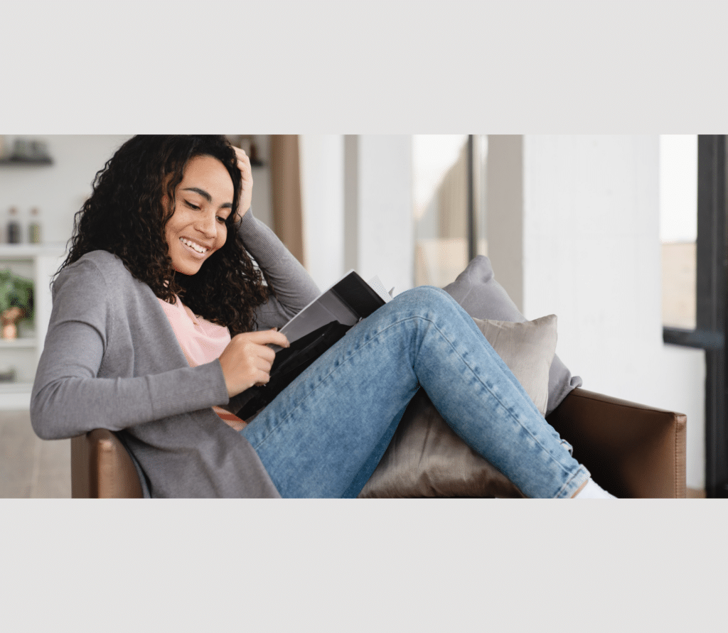 Relaxing resting young african woman freelancer student reading magazine book at home