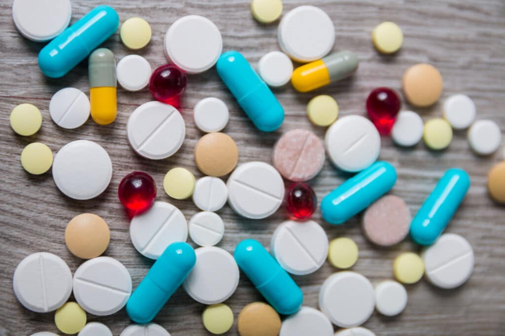 Colorfull prescription pills and capsules on a gray countertop