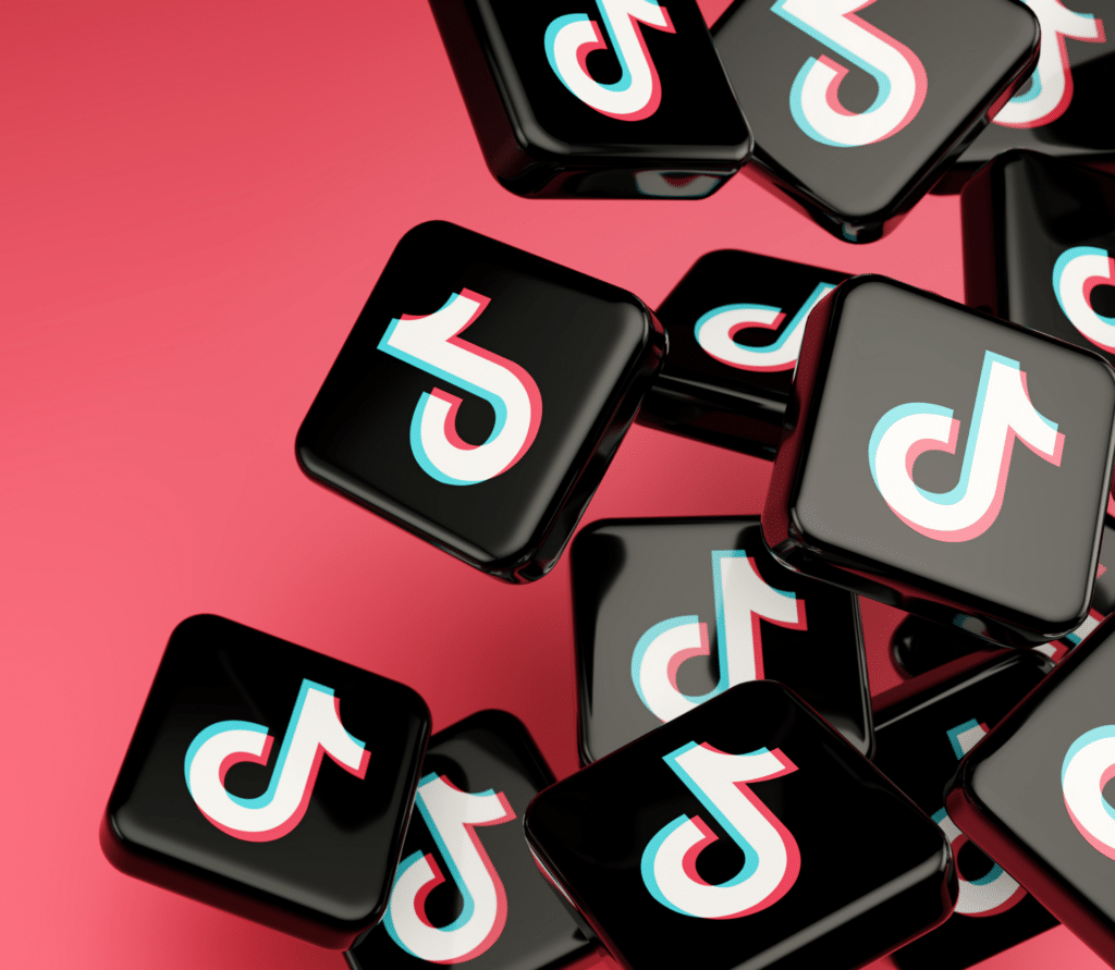 Stacked black tiles with TikTok logo on dark pink background