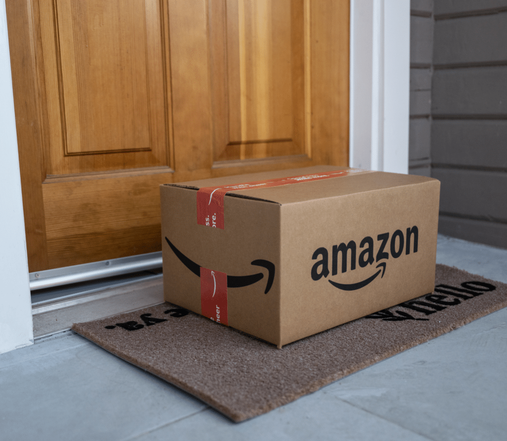 Amazon package sitting on a doormat in front of a door