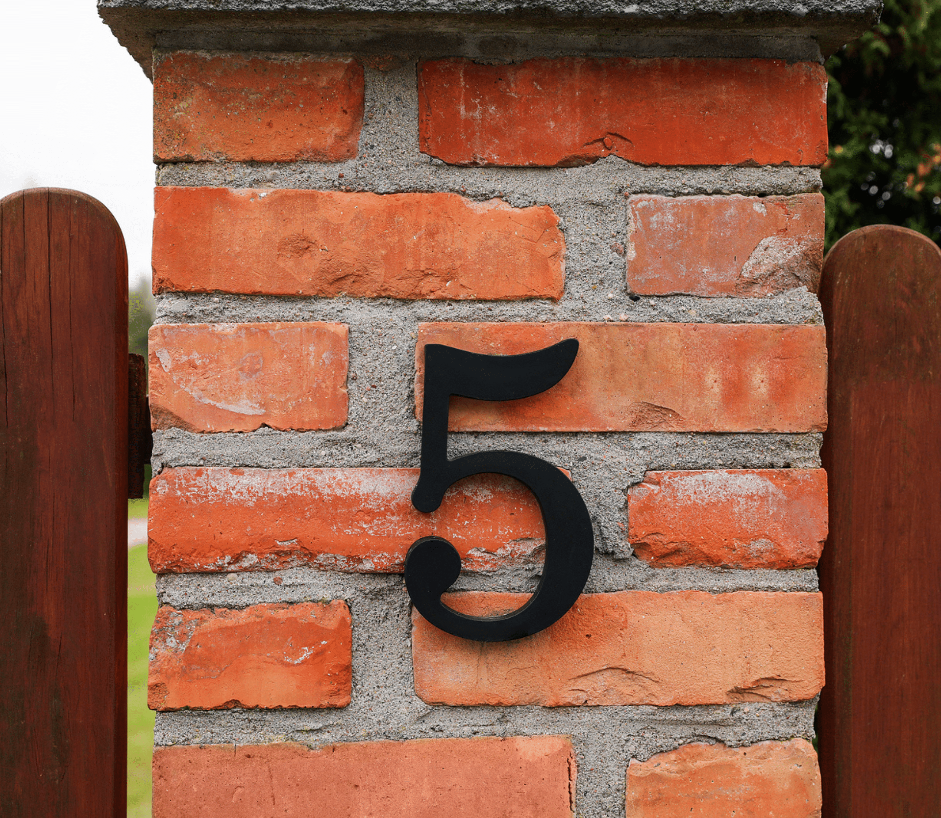 House number 5 on red brick column outdoors