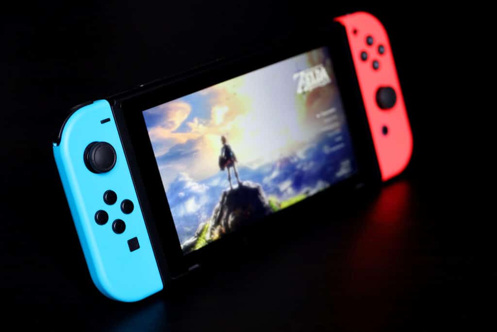 Nintendo Switch with The Legend of Zelda menu on a screen, selective focus. Video game console in handheld mode with the Joy-Con attached to its sides