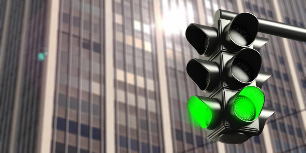 Green light concept.Traffic light, green go signal, on business office building background.